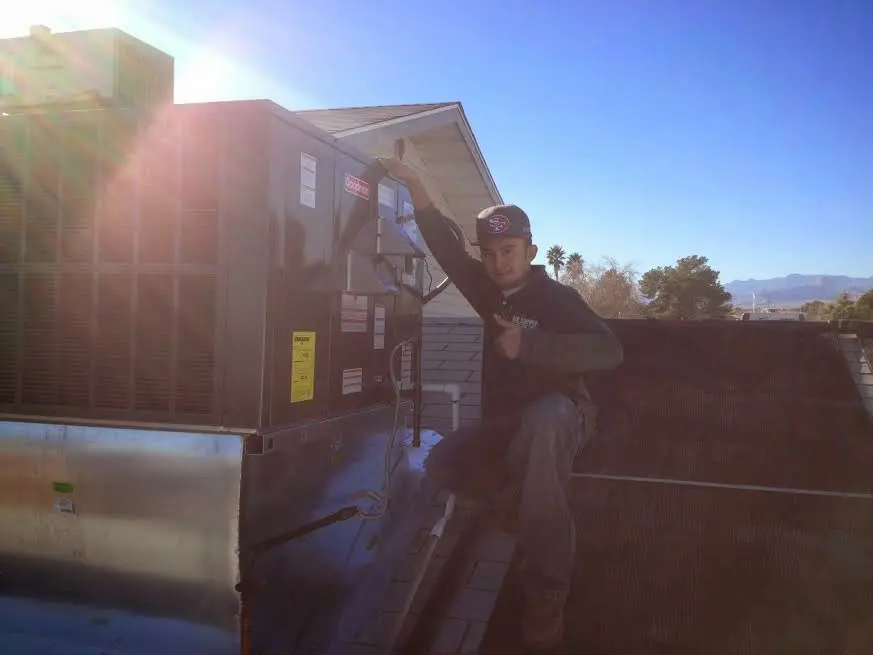 HVAC technician performing Boiler Repair on a rooftop unit in Briar